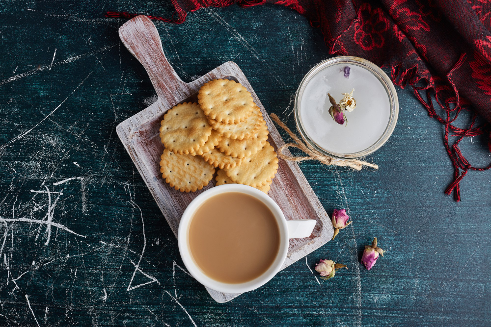 "Masala chai tea served with crispy Ritz crackers on a wooden board at Karma Indian Bistro, Vancouver"